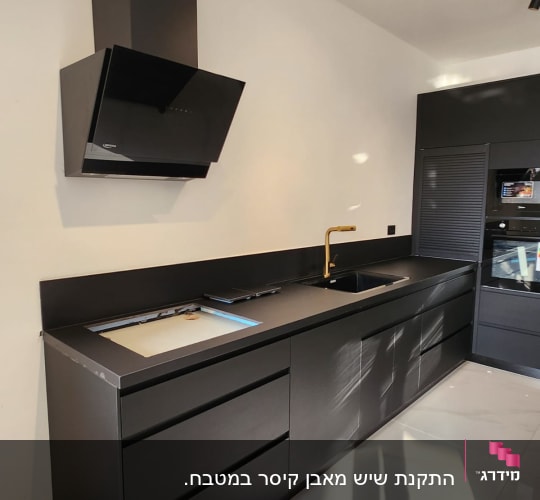 רצפת שיש לבנה במטבח מודרני עם ארונות שחורים